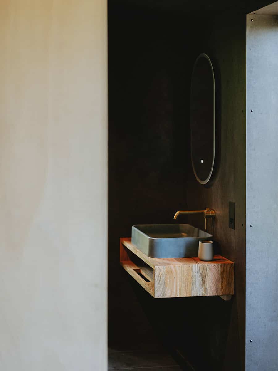 Elmore Treehouses bathroom detail with brass tap, stone basin and timber vanity shelf